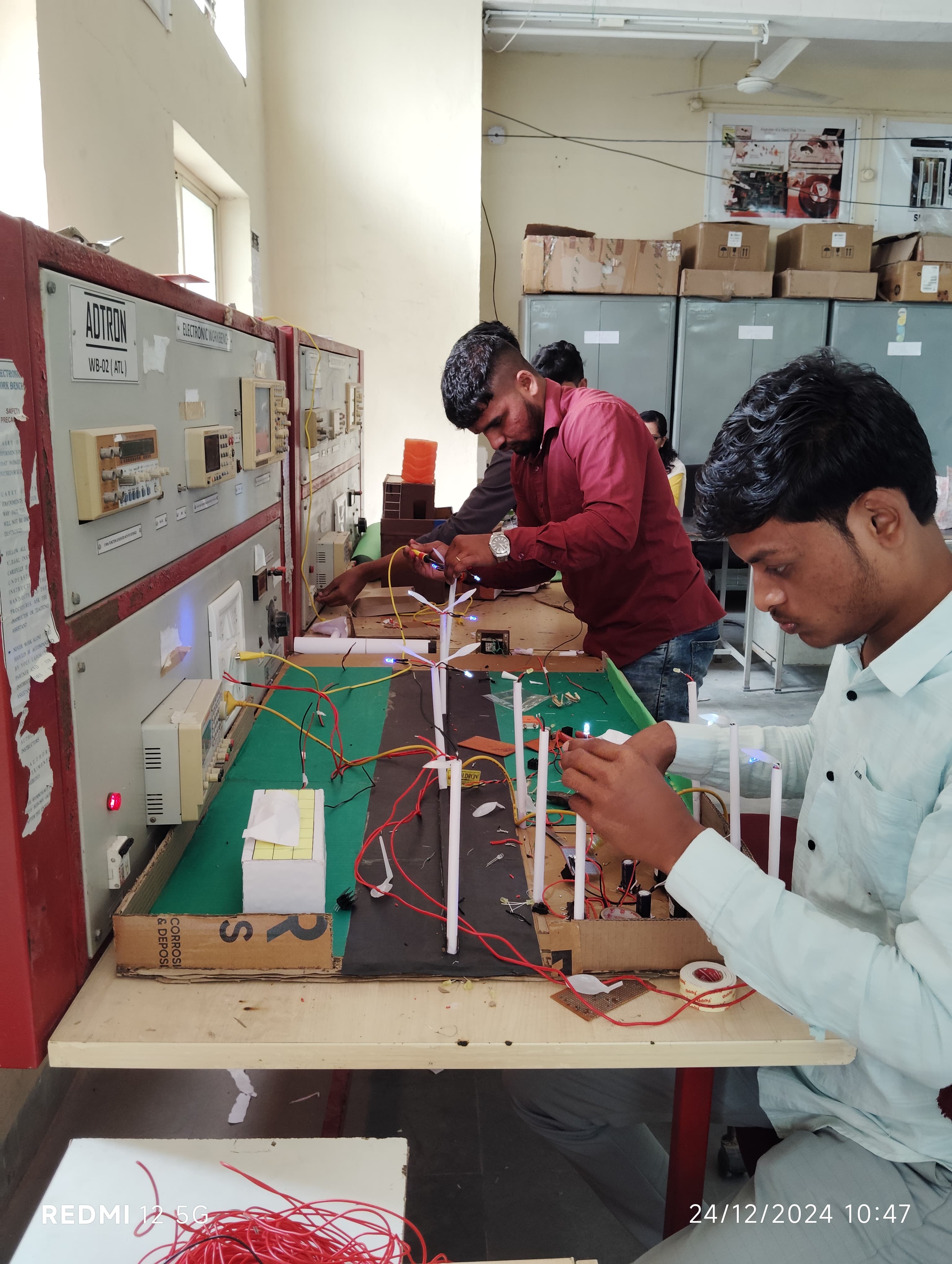 Trainees testing a project model with a multimeter
